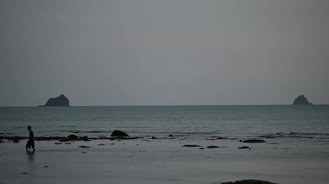 Man walking between offshore islands at Tubkaek Beach