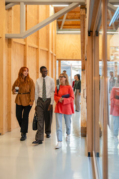 Professionals walking and talking in modern corridor