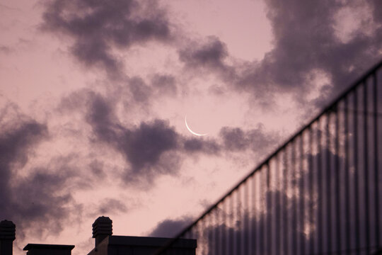 Small Crescent Moon Under Clouds at Dusk