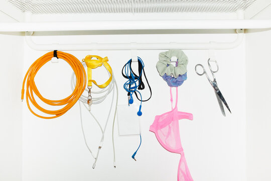 Colourful funny daily life objects hanging from hooks with flashlight 
