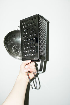 Hand holding shiny silver kitchen tool grater with flashlight