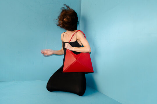 Red Handbag In Motion In Blue Studio