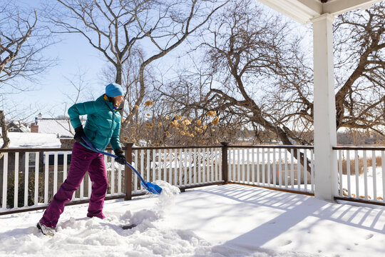 Woman shovels chore  snow after snowstorm 