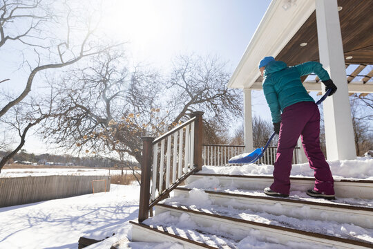 Woman shovels lift snow after snowstorm landscape 