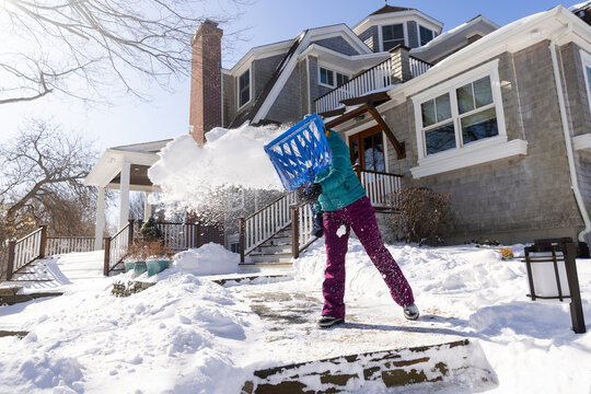 Woman shovels snow after snowstorm home background 