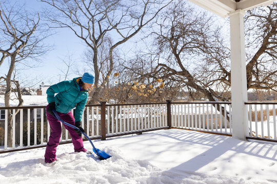 Woman shovels snow after snowstorm in cold