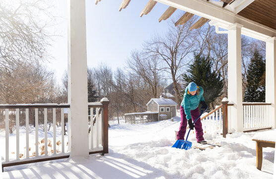 Woman shovels Ice snow after snowstorm 