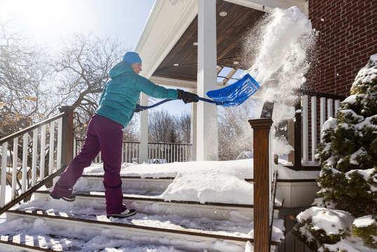 Woman shovels snow in air  after snowstorm 