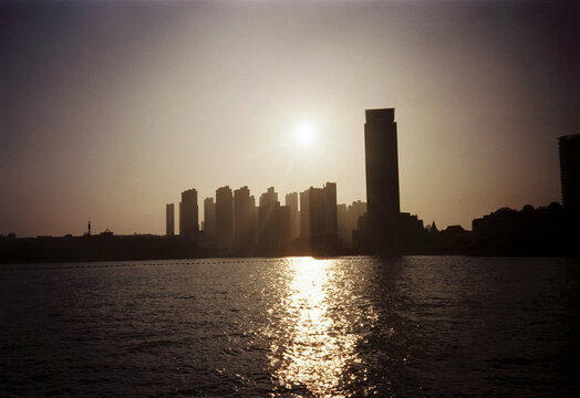 Sunset Over Modern City Skyline Reflected on Water