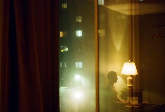 Silhouette's reflection of a man in a bedroom over a window