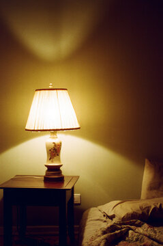 View of wrinkled bedsheets with vintage shade lamp.