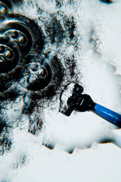 a kaleidoscopic image of hair and a shaving razor near a drain