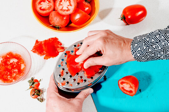 a man using a metal grater to grate tomatoes