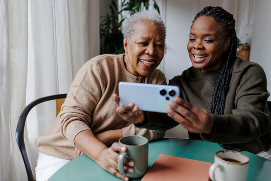 Family members laughing watching content on smartphone