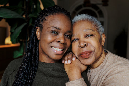 Mother and daughter connecting with affection while looking at camera
