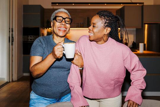 Mother and daughter enjoying coffee time at home ugc