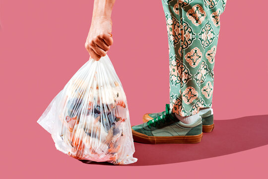 a man picks up a trash bag with food waste from the floor