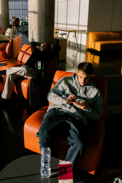 Friends sitting in airport waiting area in Morocco using their phones