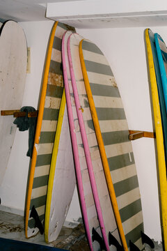 Shot lit with flash of multiple surfboards neatly arranged on a rack