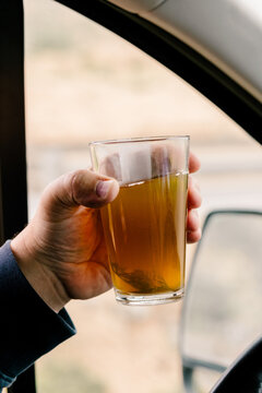 Unknown hand holding a glass with traditional Moroccan tea