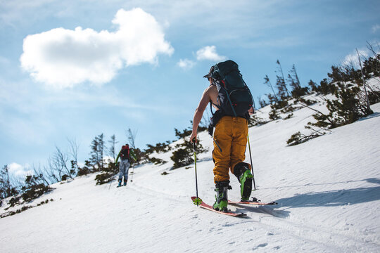 Freeride skiing in remote backcountry mountains under clear winter sky