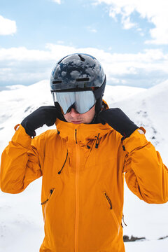 Close-up portrait of a man in an orange jacket wearing mirrored google