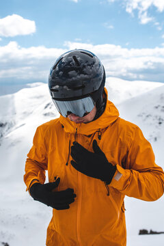 Close-up portrait of a man in an orange jacket wearing mirrored google