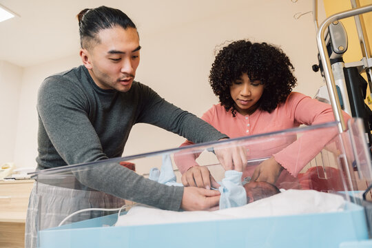 Parents caring for newborn baby in hospital nursery