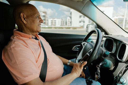 Elderly Man Driving a Car in the city 
