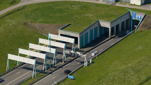 Aerial view of the Westerscheldetunnel entrance and bus station with highway lanes and green embankments in Terneuzen, Zeeland, Netherlands.