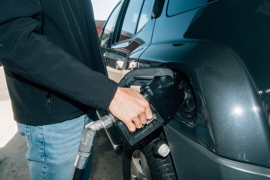 Man Filling Gas in Vehicle at Gas Station