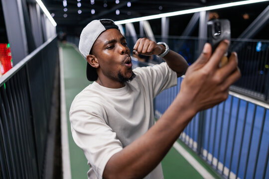 Man takes selfie on bridge with lights.