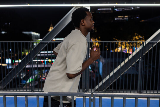 Man jogging on a bridge at night.