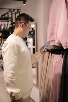 Chinese Man Shopping in Store While Using Smartphone for Assistance