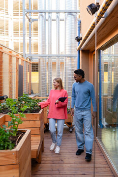 Two friends in urban rooftop garden with diverse plants
