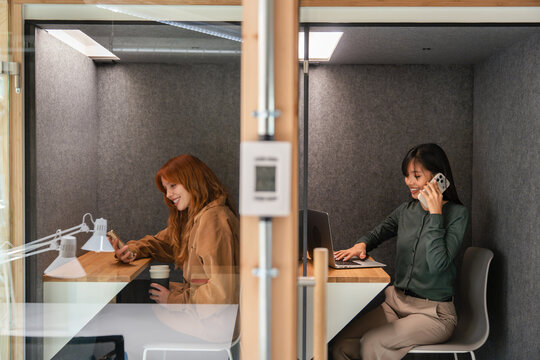 Modern workspace with two women working in soundproof booths