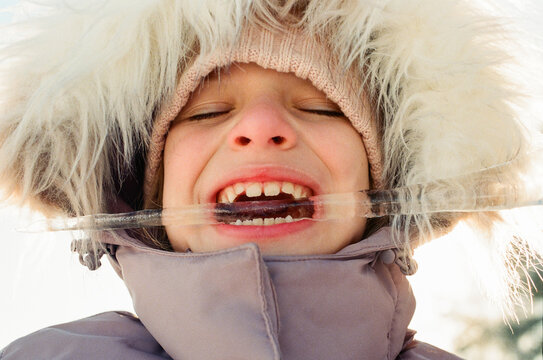Close Up of Smiling Child Biting Ice in Winter