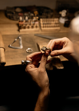 Woman's hands holding a big ring on a jewelry workbench 