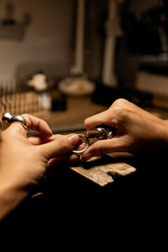 Jeweler is polishing workpiece with hand file
