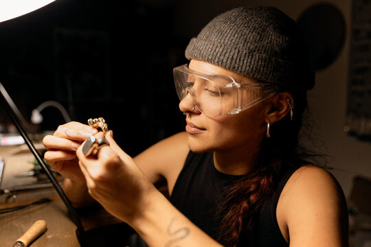 Goldsmith shaping metal with coping saw
