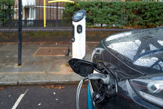 Electric Car Charging at Station During Rainy Day in London