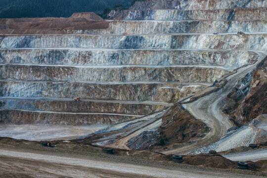 Terraced open pit mine with haul truck on upper level