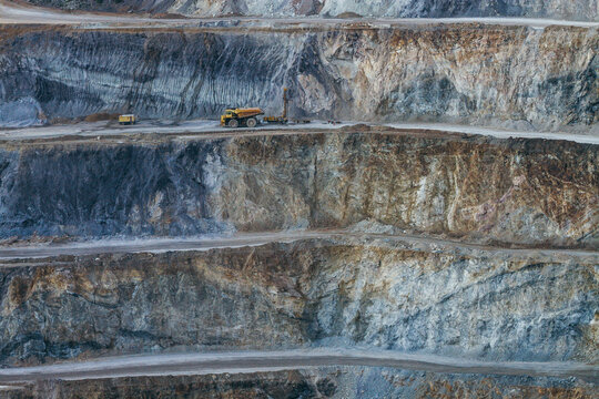Terraced open pit mine with haul truck on upper level