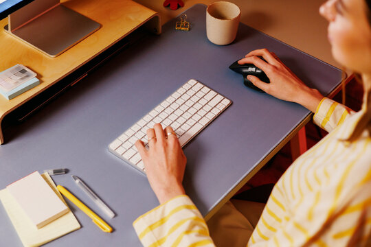 Woman working at desk with keyboard and mouse