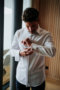 Man buttoning shirt sleeve 