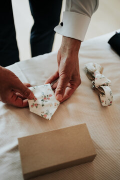 Groom selecting floral bow tie before ceremony