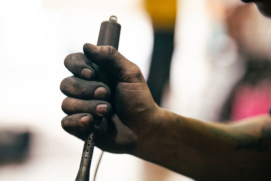 Mechanic's grimy hand gripping tool symbolizing hard work