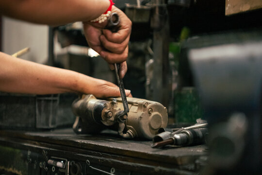 Auto mechanic hands repairing engine starter motor