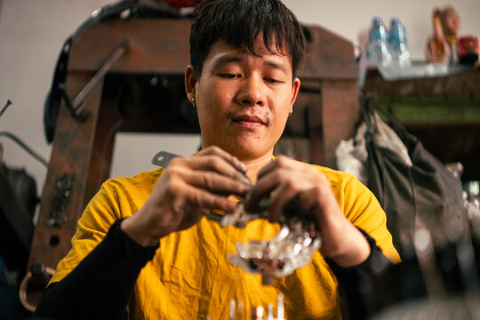 Mechanic concentrating on assembling small metal car components