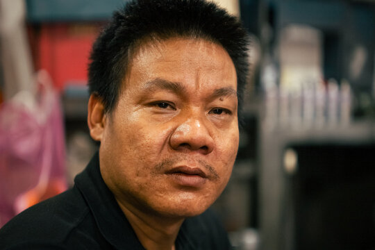 Male asian mechanic looking at the camera